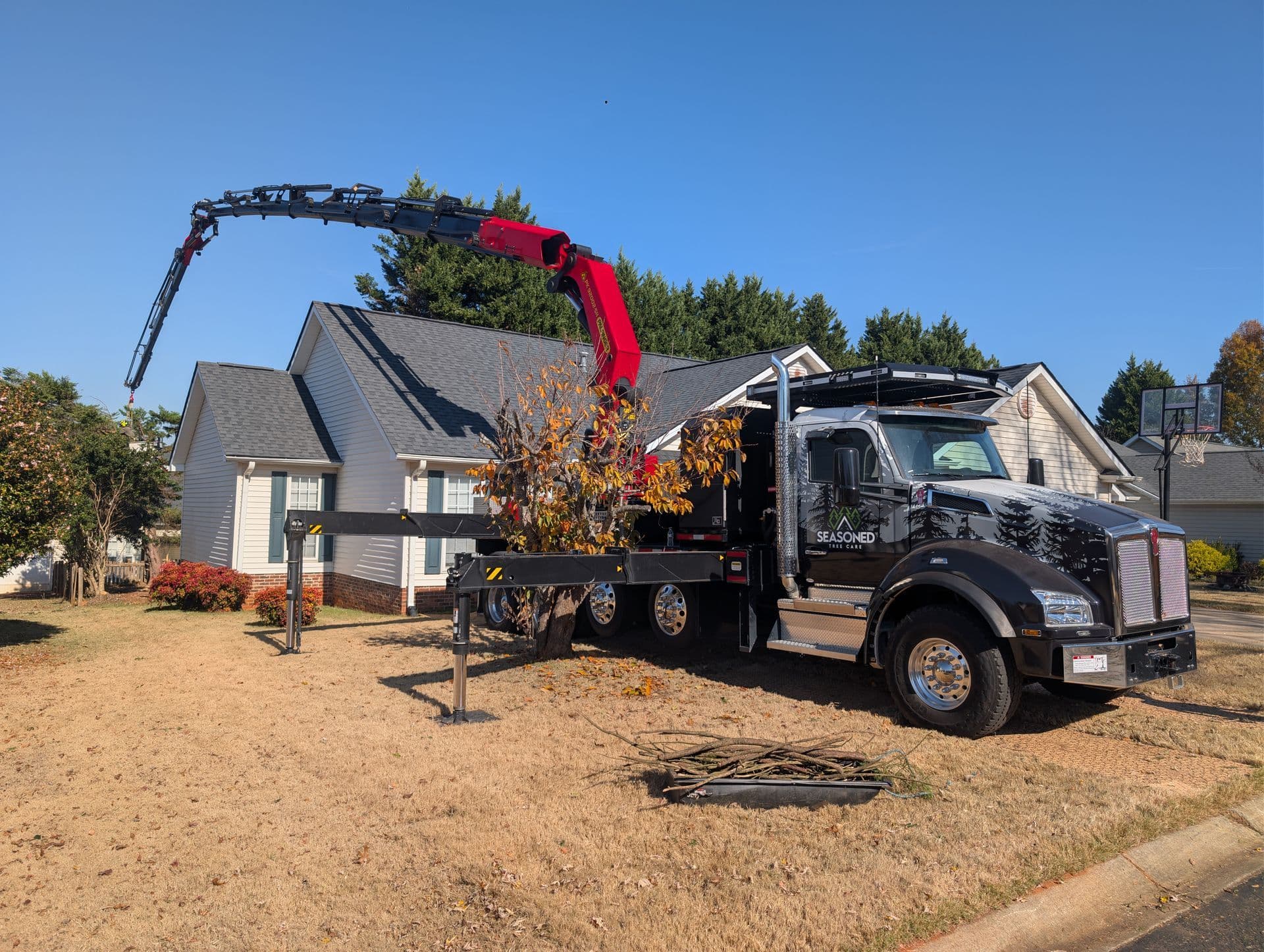 Palfinger crane lifting a massive tree section during a removal in the Upstate